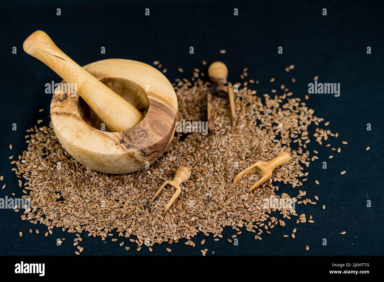 a pile of flaxseeds and utensils made of olive wood Stock Photo Alamy
