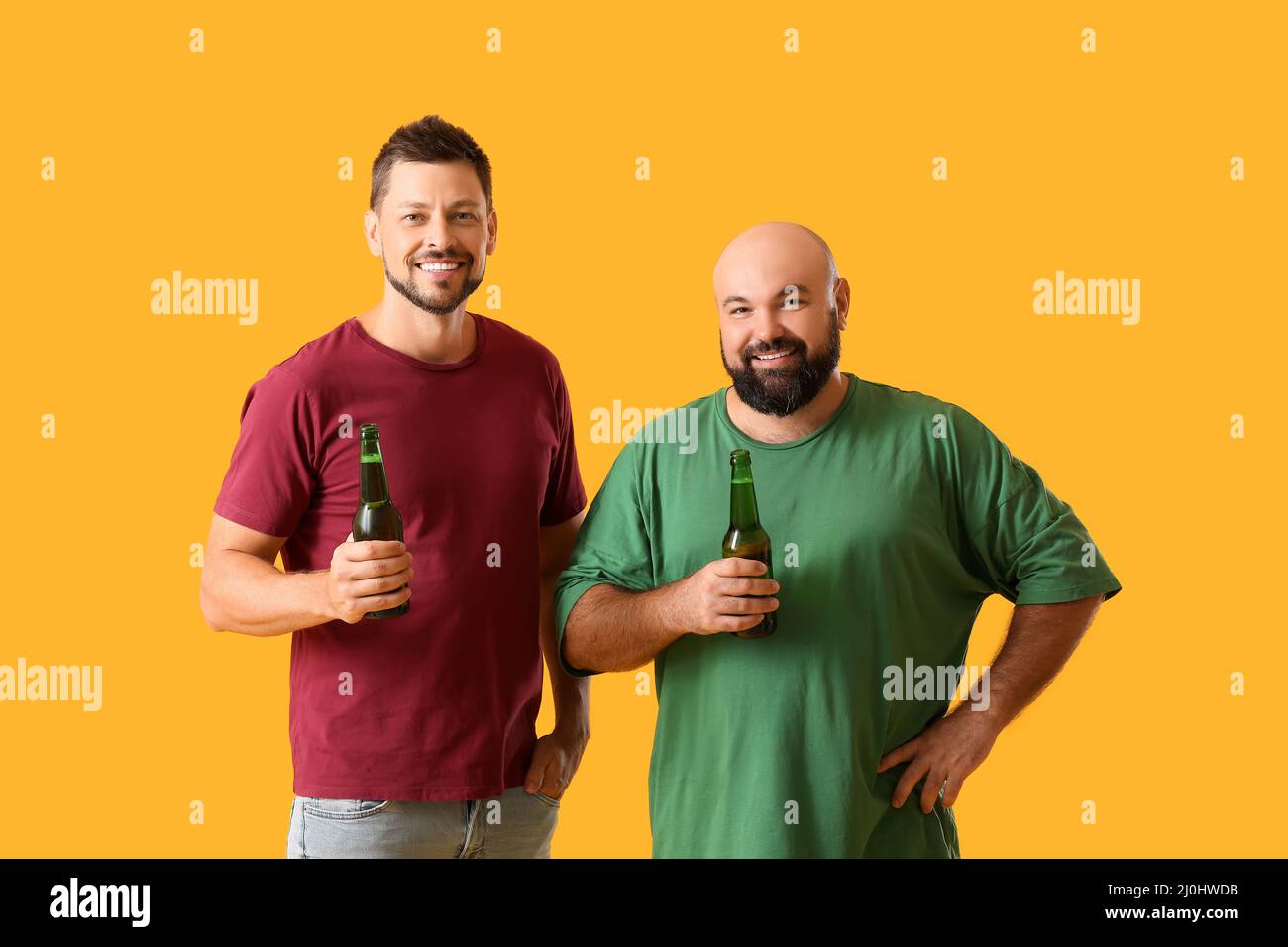 Men drinking beer on yellow background Stock Photo Alamy
