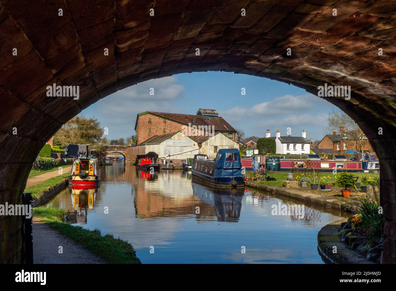 Canal narrowboats passing under a bridge on the Shropshire union canal