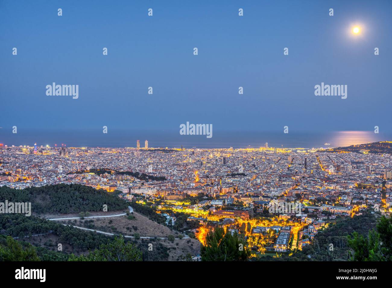 Barcelona at night with a full moon Stock Photo