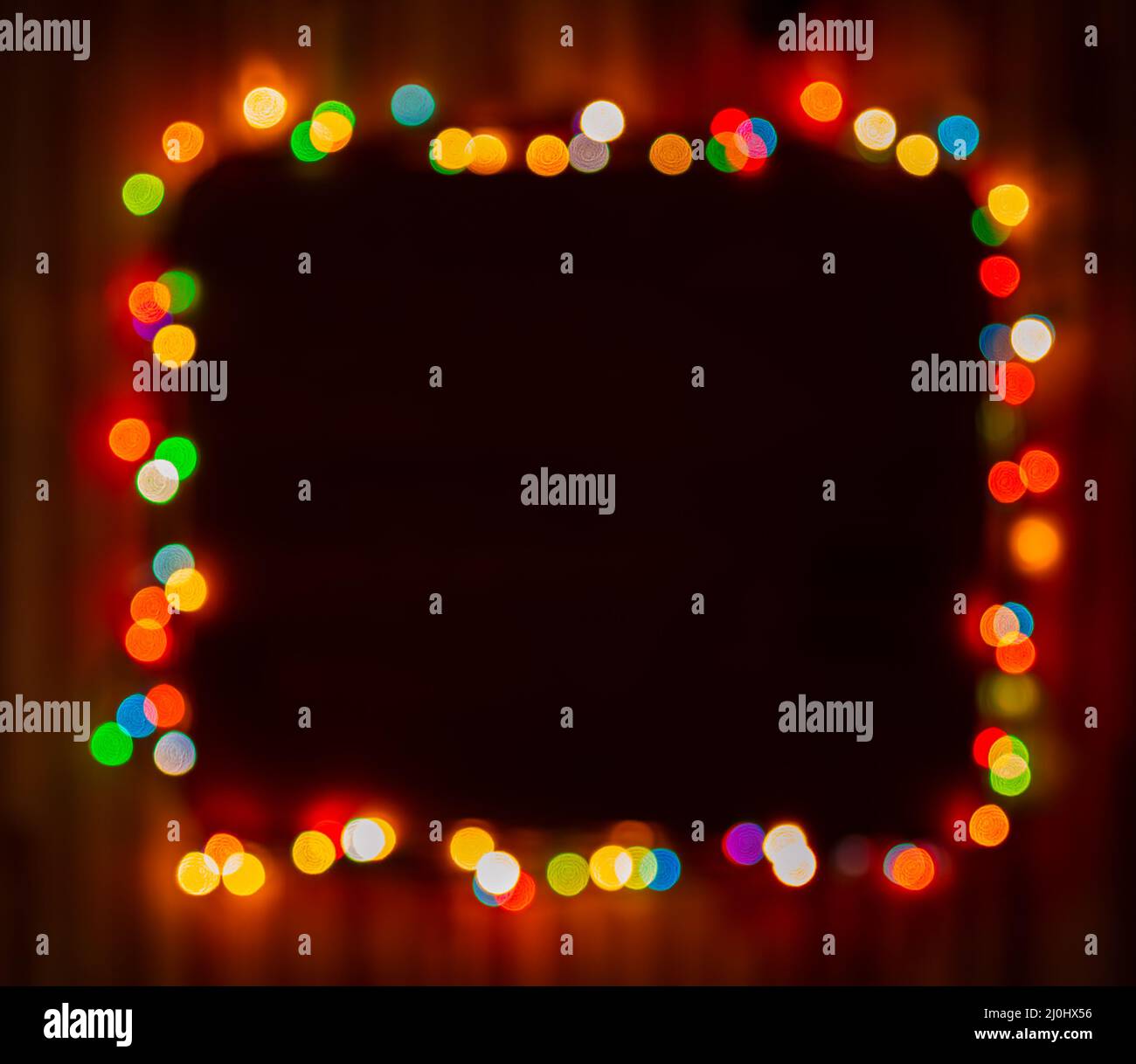 Blurred christmas lights frame on dark background Stock Photo