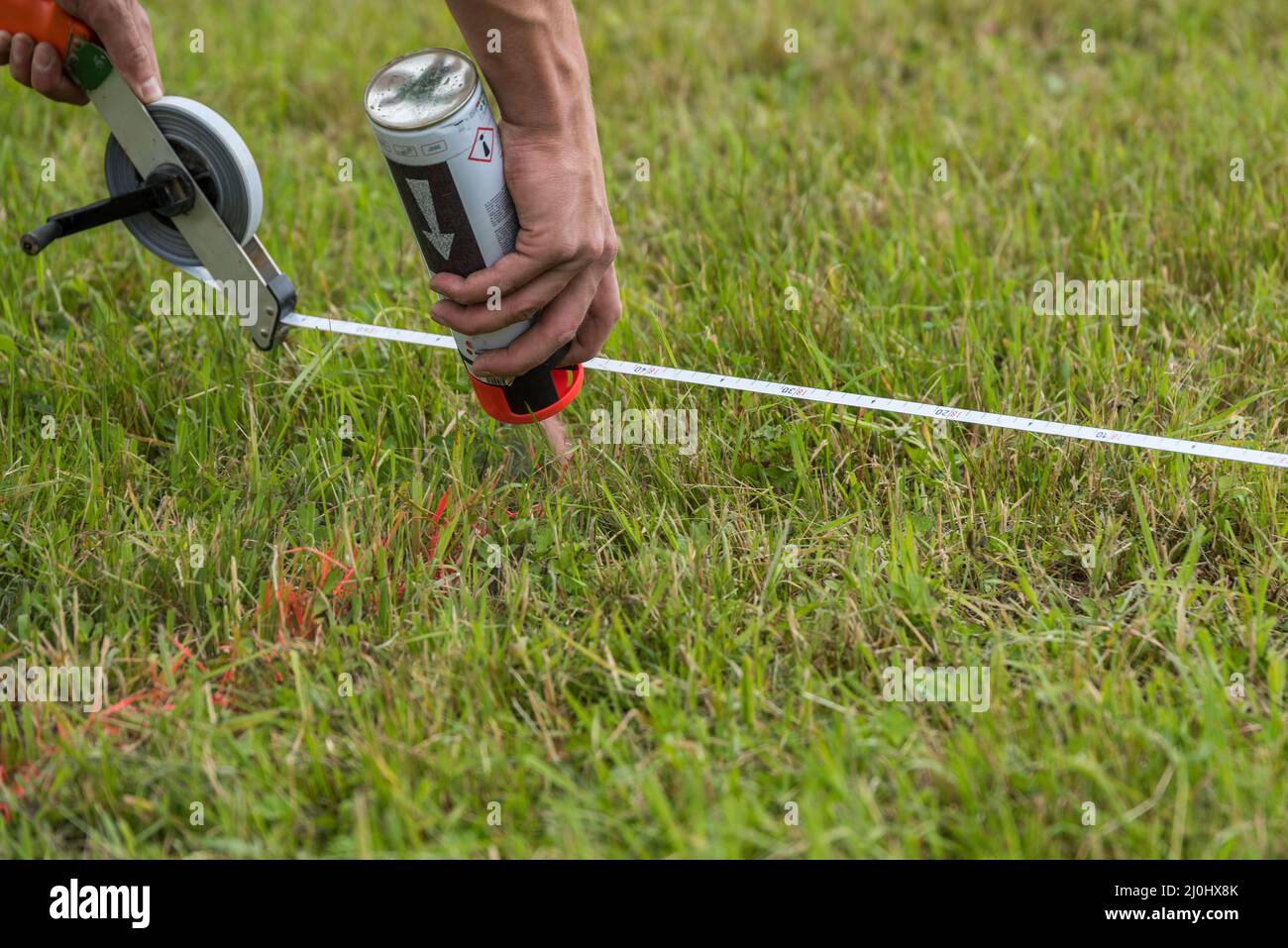 Construction worker marks building plot - surveying, close-up Stock Photo