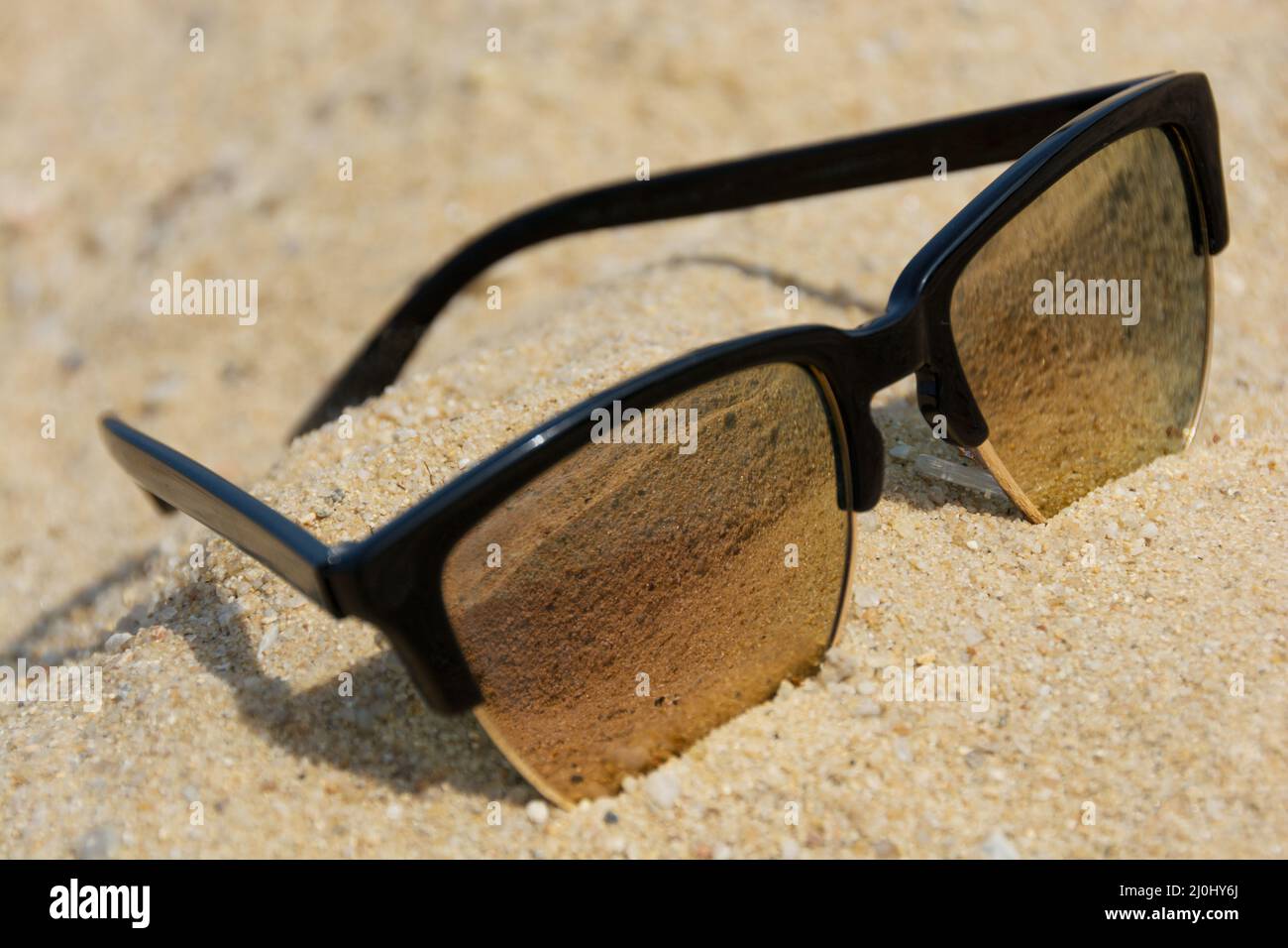 Modern sunglasses lies in the sand Stock Photo