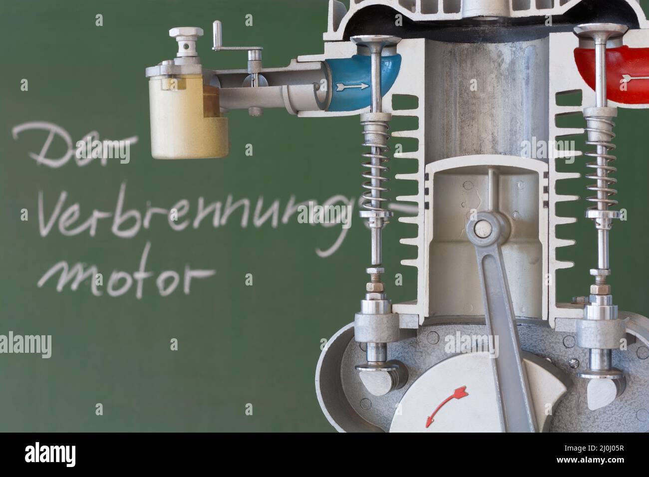 Cutaway model of an internal combustion engine with a blackboard in the background and German text Stock Photo