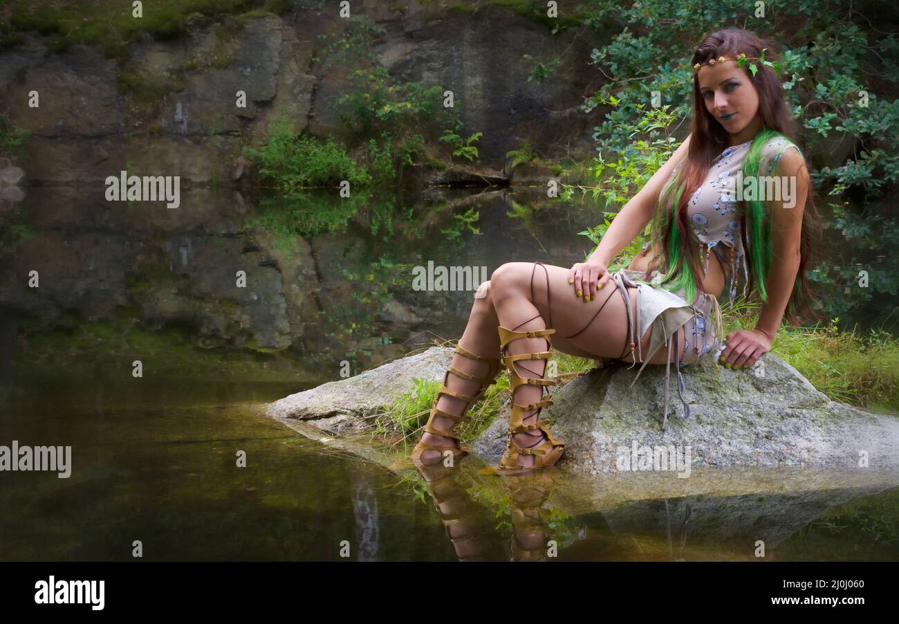 Woman sitting seductively by the water Stock Photo