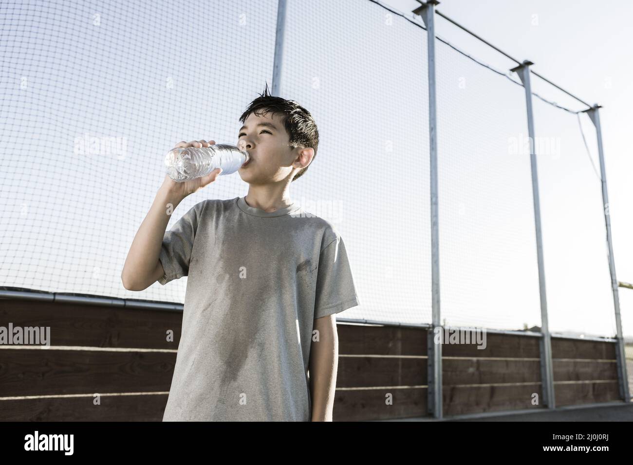 Boy drinks water on a hot day. Stock Photo