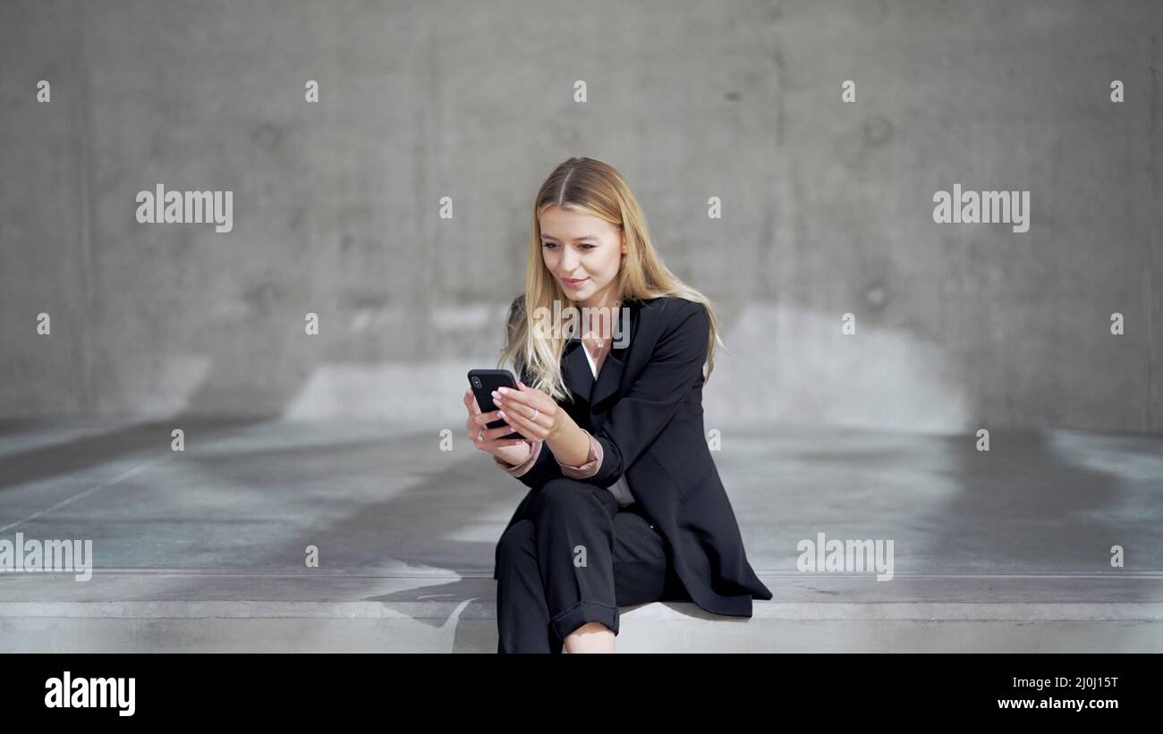 Glad businesswoman using mobile phone Stock Photo