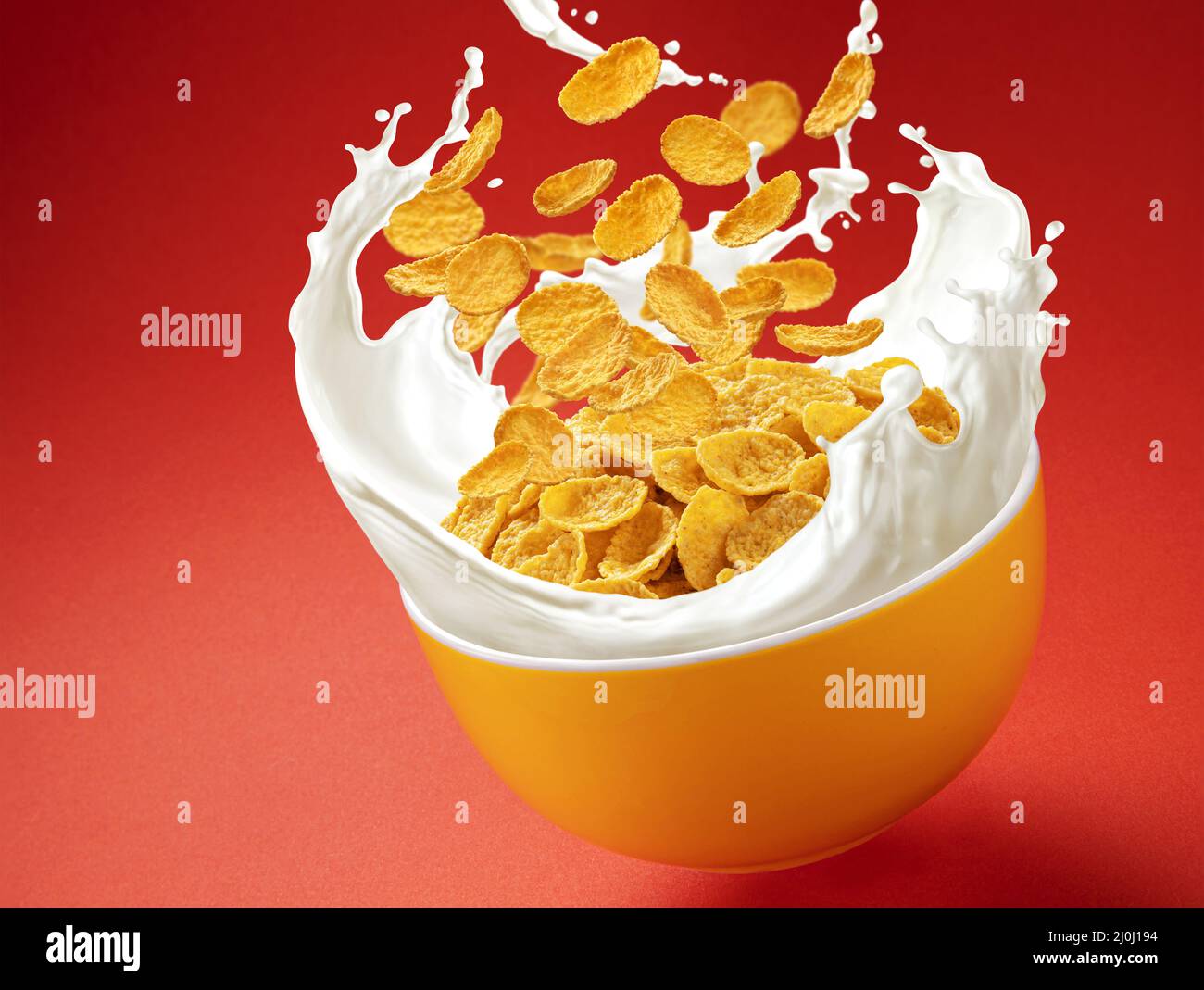 Corn flakes with milk splashes on red background Stock Photo