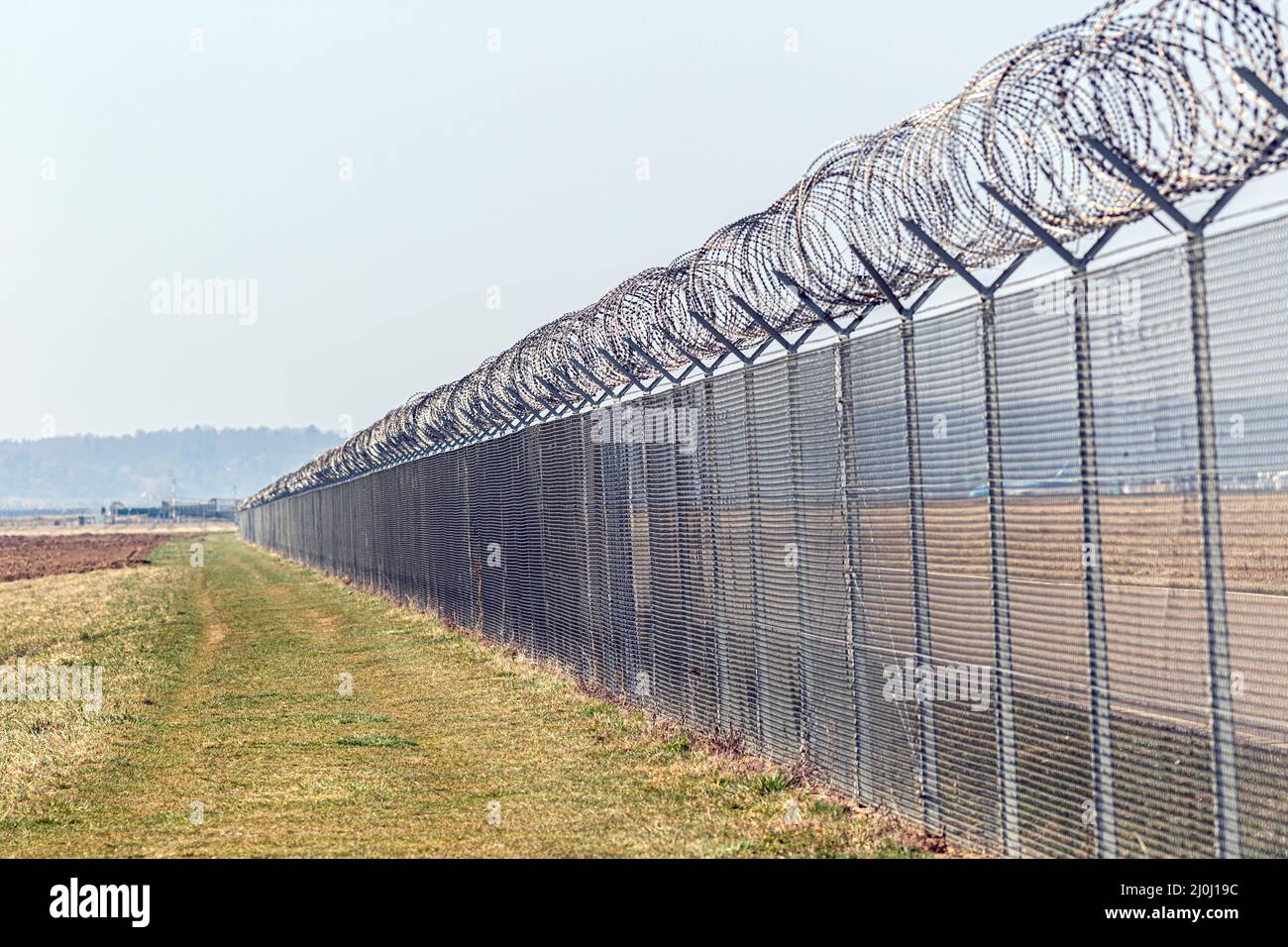 a barbed wire fence to protect a border Stock Photo - Alamy