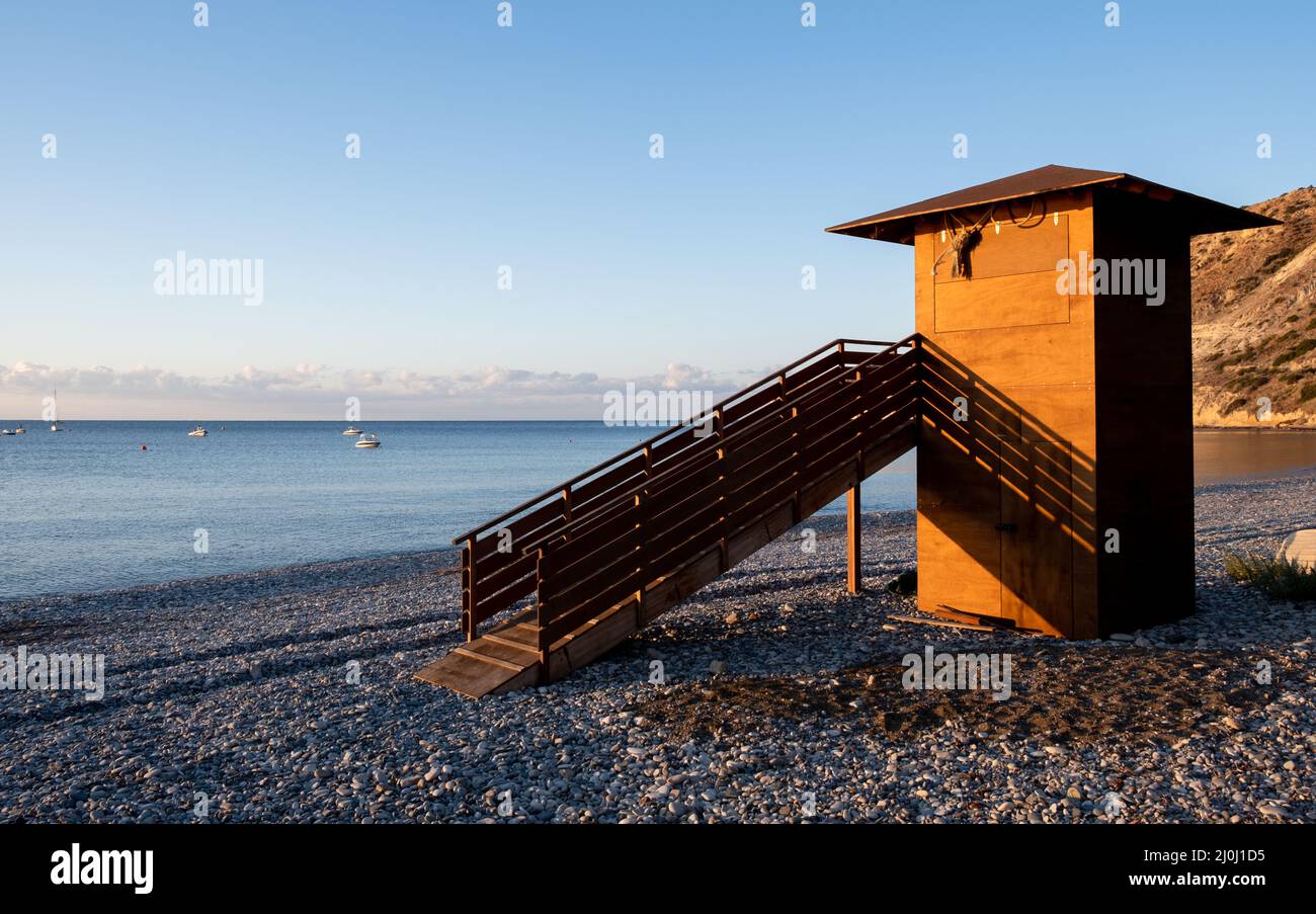 Lifeguard wooden tower at sunrise. Empty beach Pissouri Cyprus Stock Photo