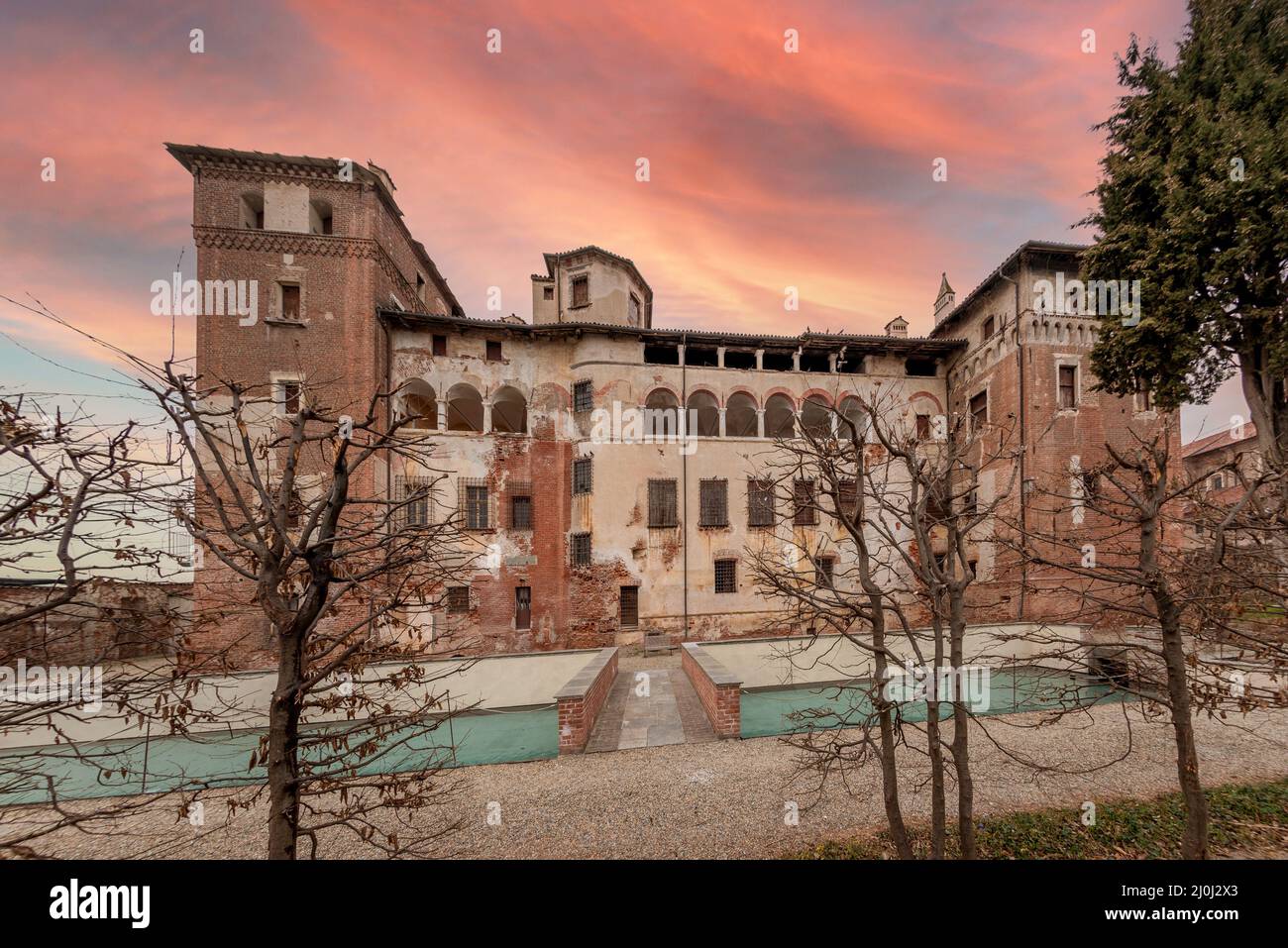 Lagnasco, Cuneo, Italy - March 16, 2022: The Castles of the Marquises Tapparelli D'Azeglio (11th to 18th century) with sky with colored sunset clouds Stock Photo
