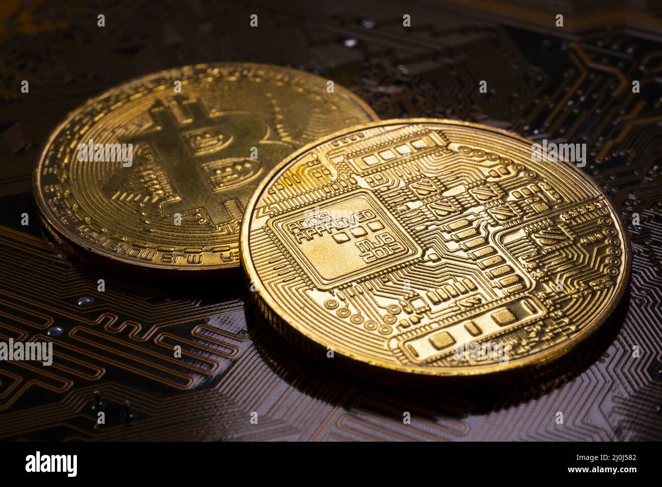 Two Bitcoin coins and printed circuit board PCB Stock Photo