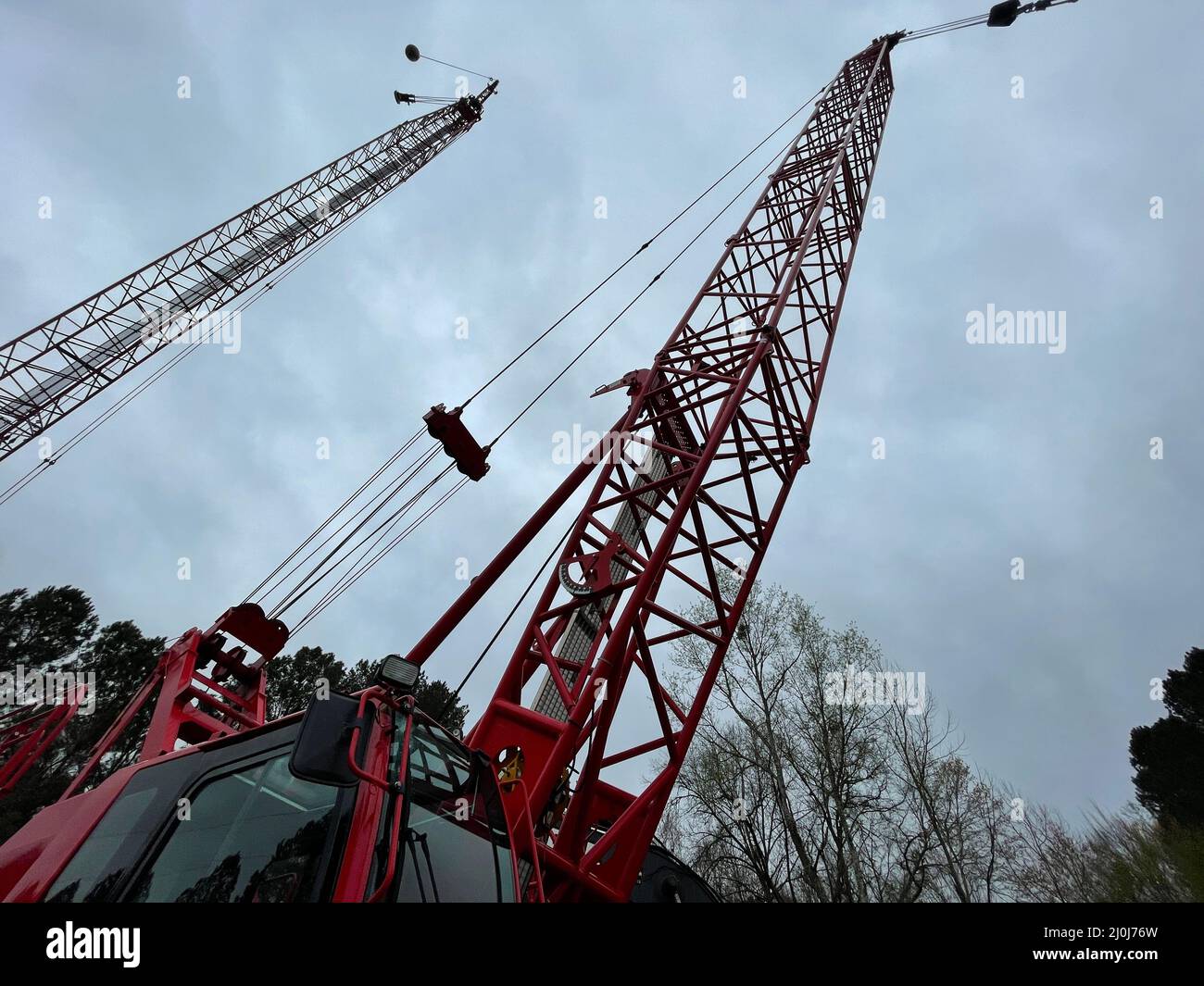 Augusta, Ga USA - 03 19 22: Manitowoc Red Crane Construction scene cloudy rainy day two booms and sky Stock Photo