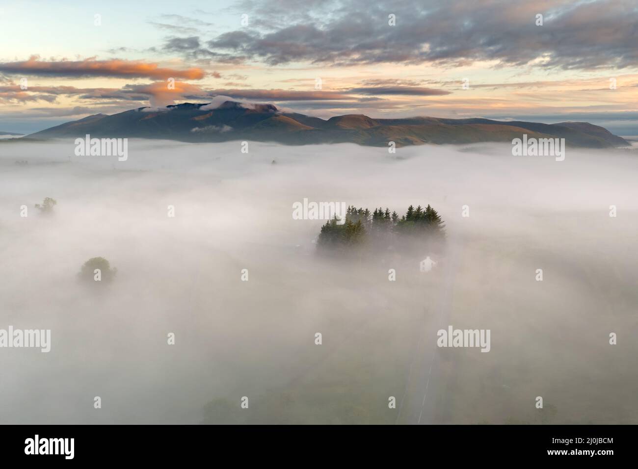 Breathtaking scenic view of misty valley in morning fog. Lake District, UK. Majestic British landscapes. Aerial drone photography. Stock Photo