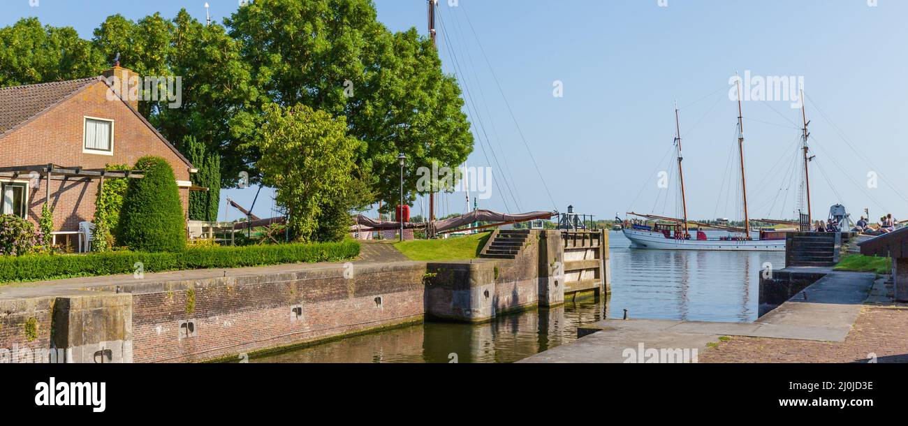 Enkhuizen, The Netherlands - July 20, 2021: Cityscape Enkhuizen with ships entering the historic harbor in the center of historic fishing village in North Holland in The Netherlands Stock Photo