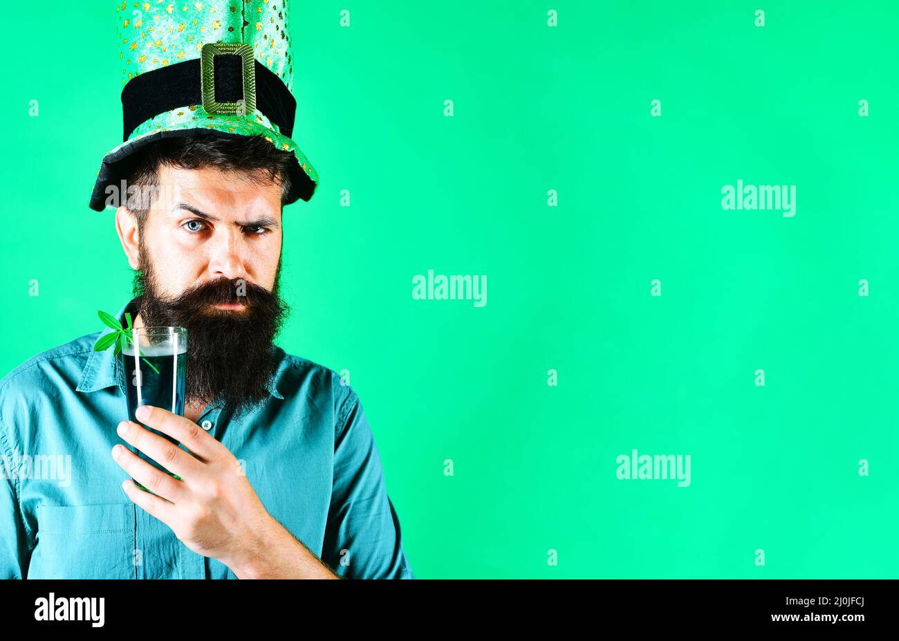 Serious man in green hat with glass of beer. Patricks Day pub party celebrating. Ireland tradition. Stock Photo