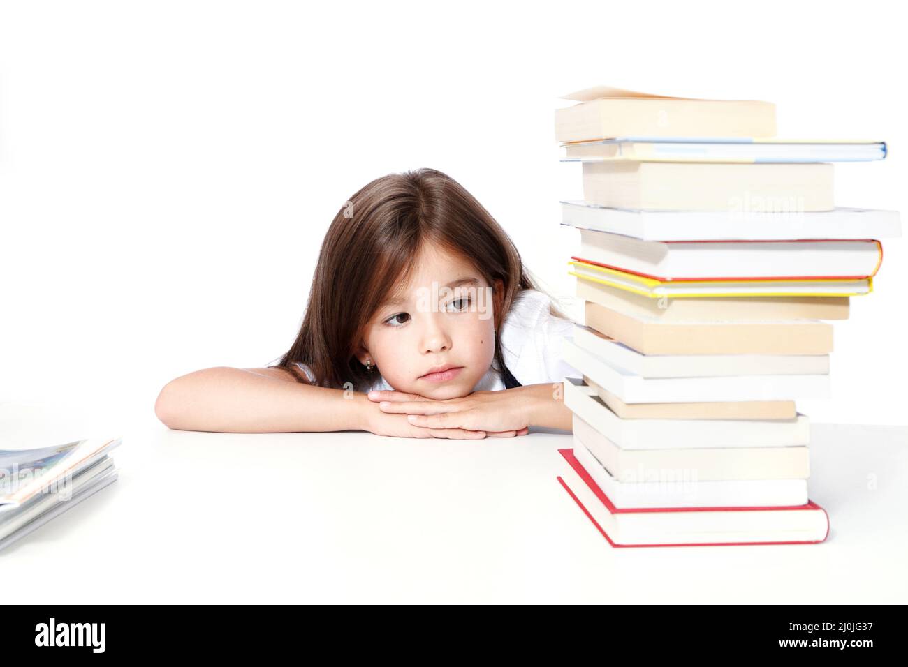 Young cute girl sitting at the table and reading a book Stock Photo - Alamy