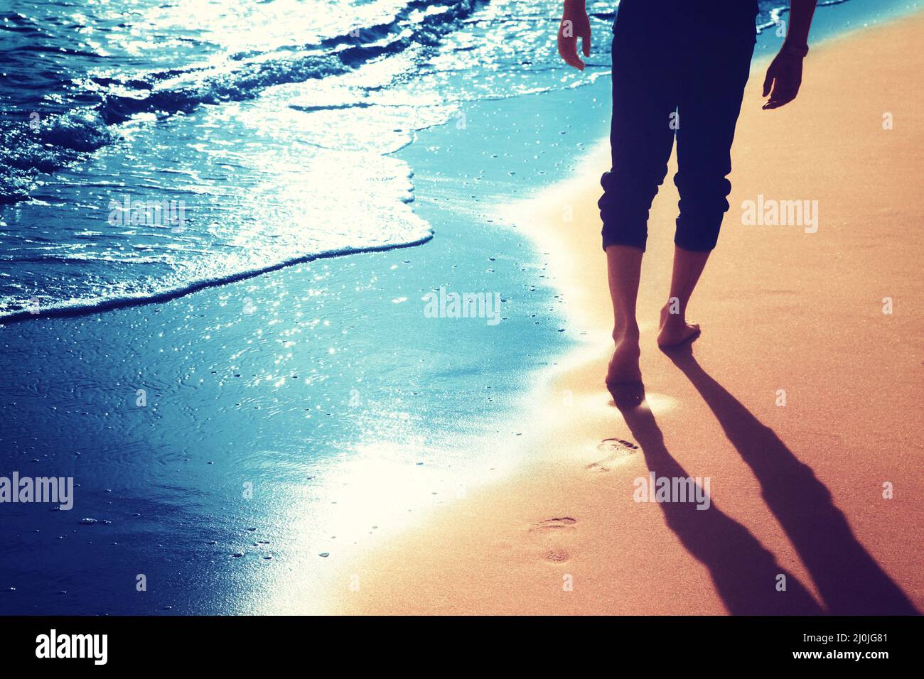 Walking on the beach, leaving footprints in the sand Stock Photo - Alamy