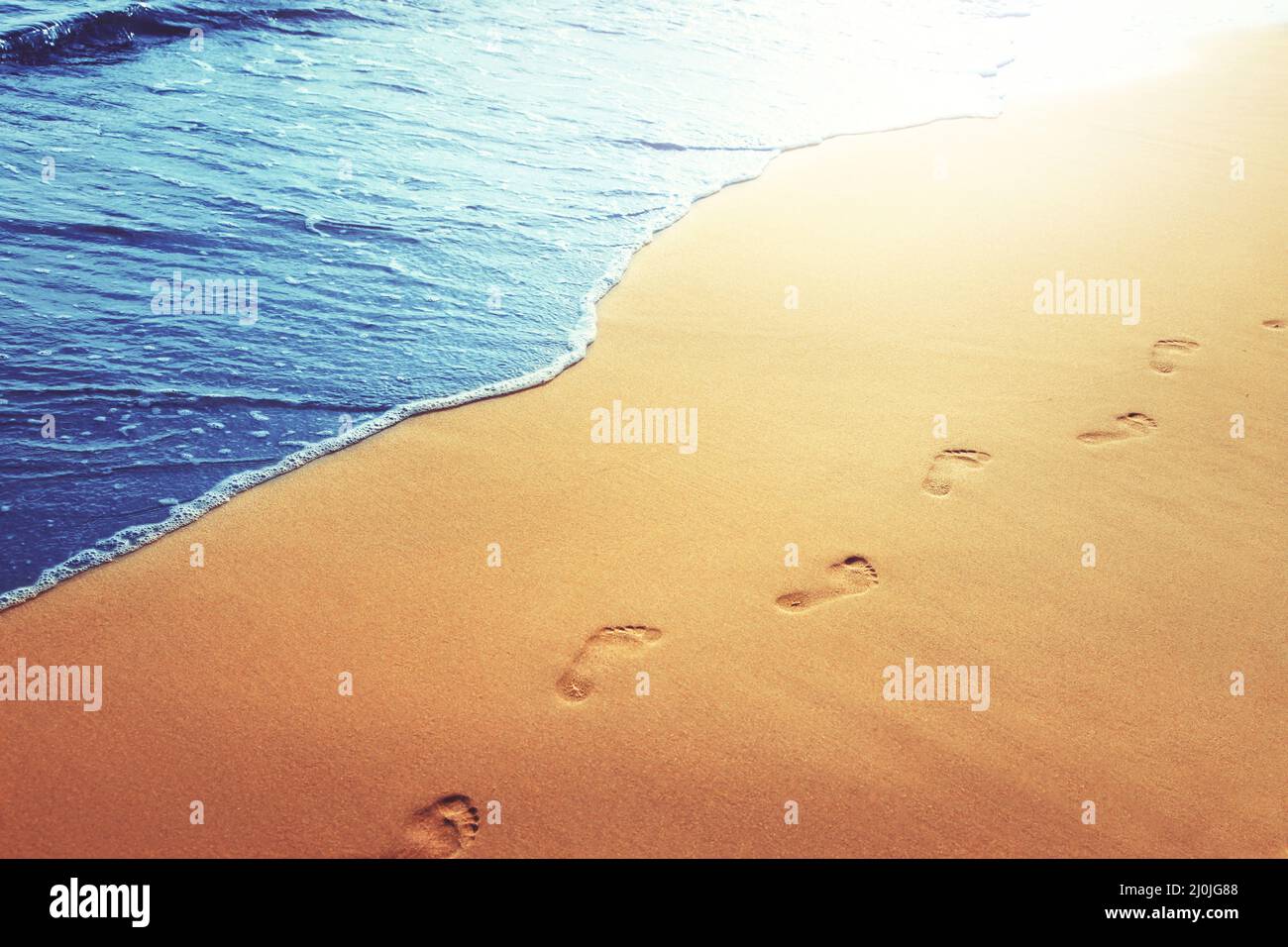 Walking on the beach, leaving footprints in the sand Stock Photo - Alamy