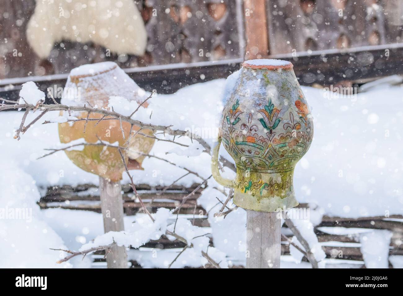 Ceramic pot in vintage style on the fence in winter. Ukrainian cultural
