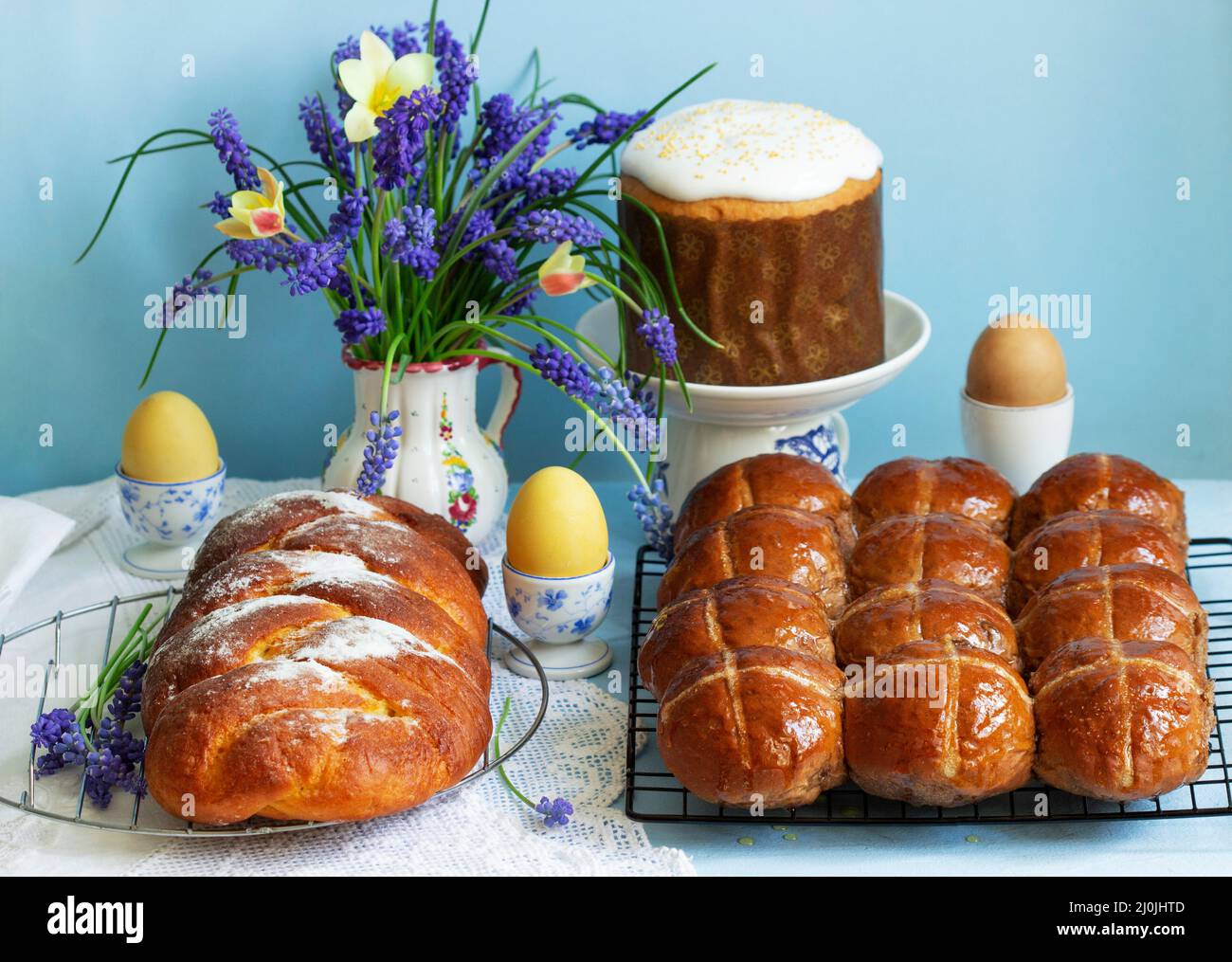 Traditional Easter pastries, cross buns, Easter cake and sweet challah and Easter eggs. Stock Photo