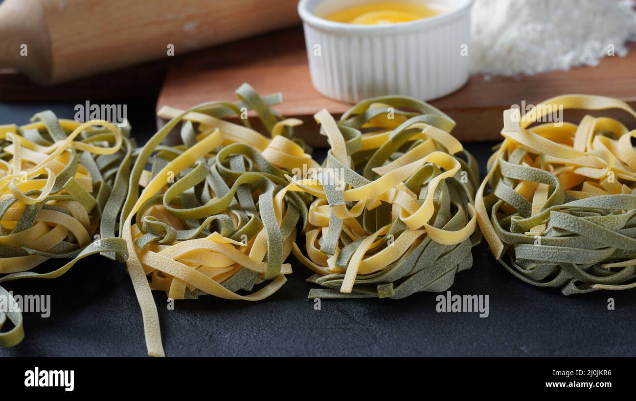 Uncooked Italian homemade egg pasta with spinach placed side by side