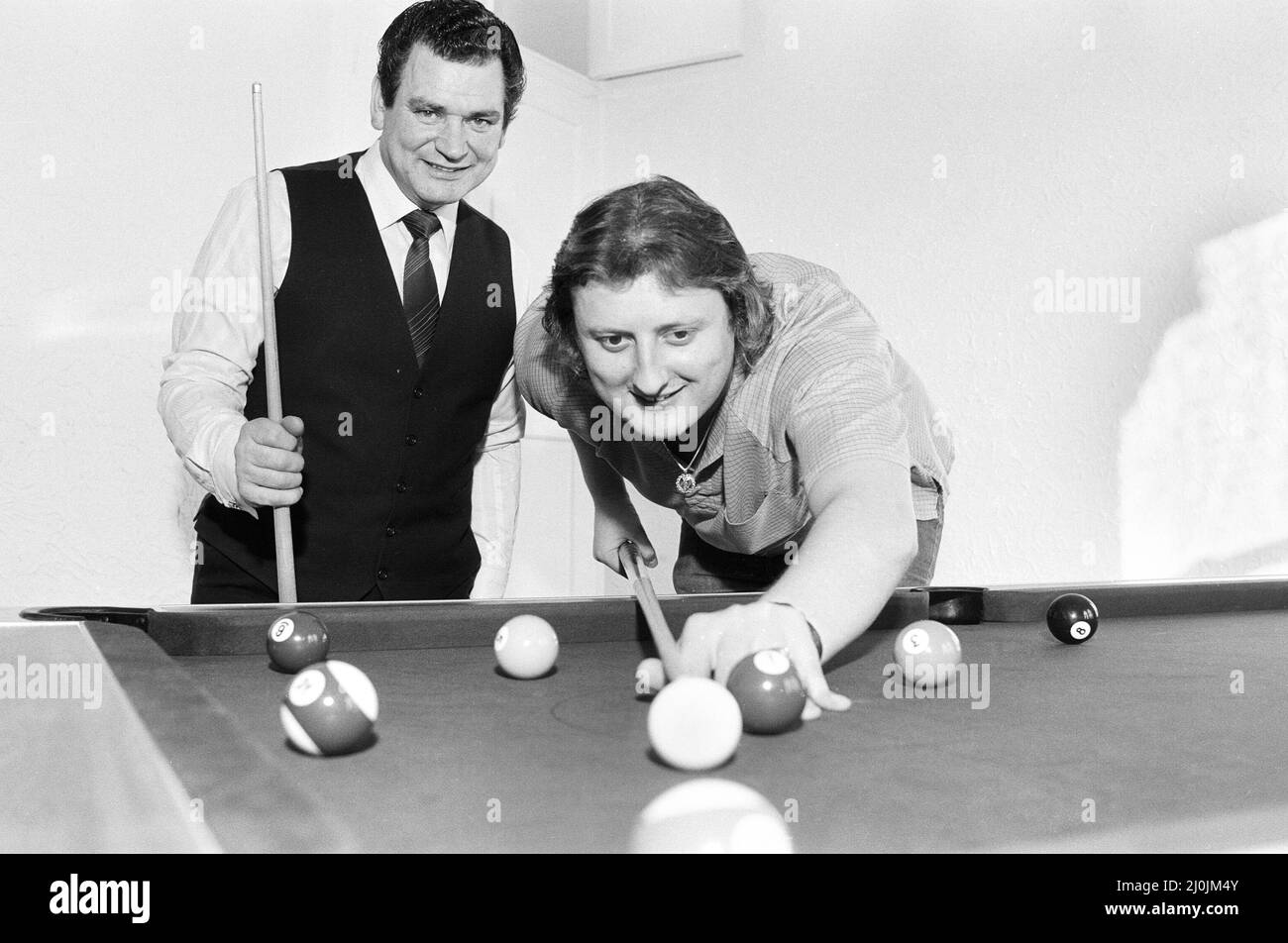 British darts player Eric Bristow pictured at his newly purchased 19th century country retreat in Staffordshire. Here he is given a lesson in the game of pool by English Number One player Peter Fox in his new games room. 21st December 1982. Stock Photo