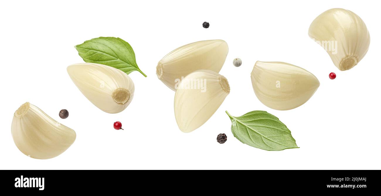 Falling peeled garlic cloves isolated on white background Stock Photo