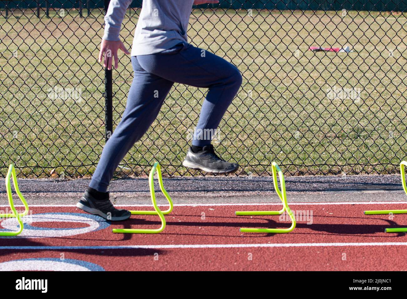 Side view of a high school boy in the track aposition standing over