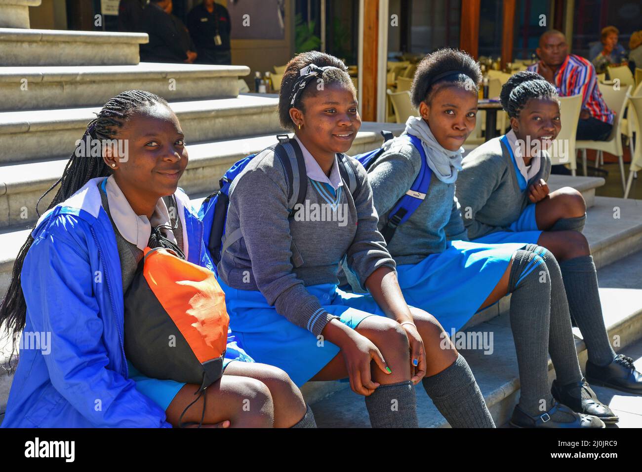 Schoolgirls sitting in Nelson Mandela Square, CBD, Sandton, Johannesburg, Gauteng Province, Republic of South Africa Stock Photo