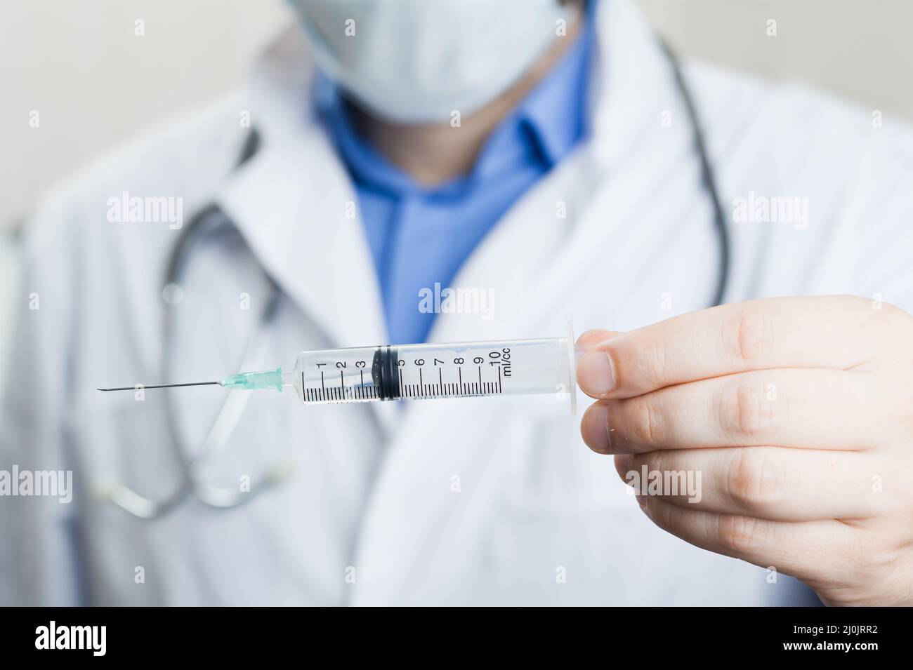 Doctor holding a syringe with vaccine against corona virus. Stock Photo