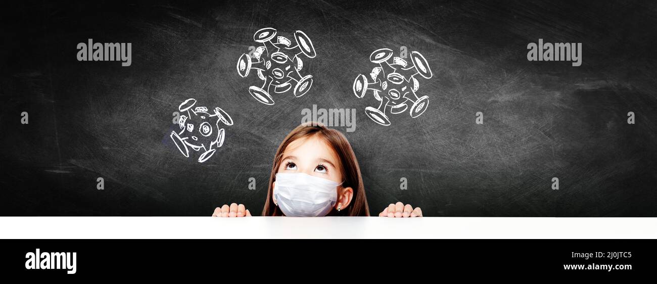 Young girl with protection mask against corona virus at school. Stock Photo
