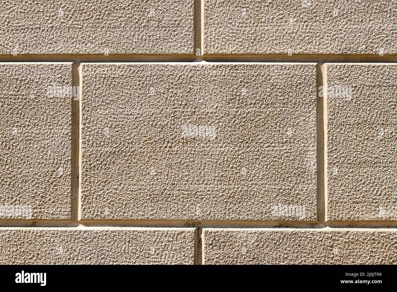 Background from a wall with rectangular beige stone slabs Stock Photo
