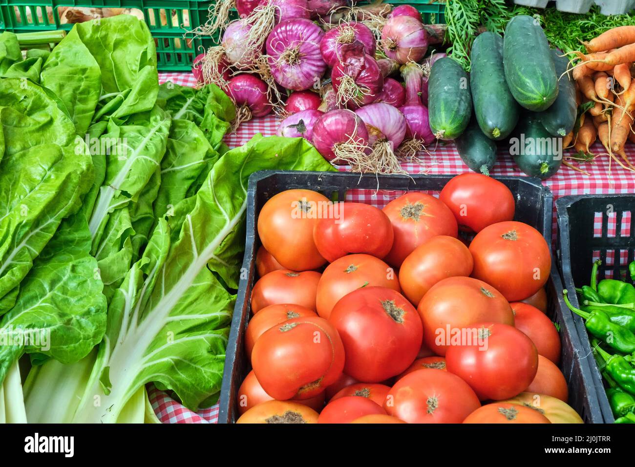 Tomatoes and salad for sale at a market Stock Photo