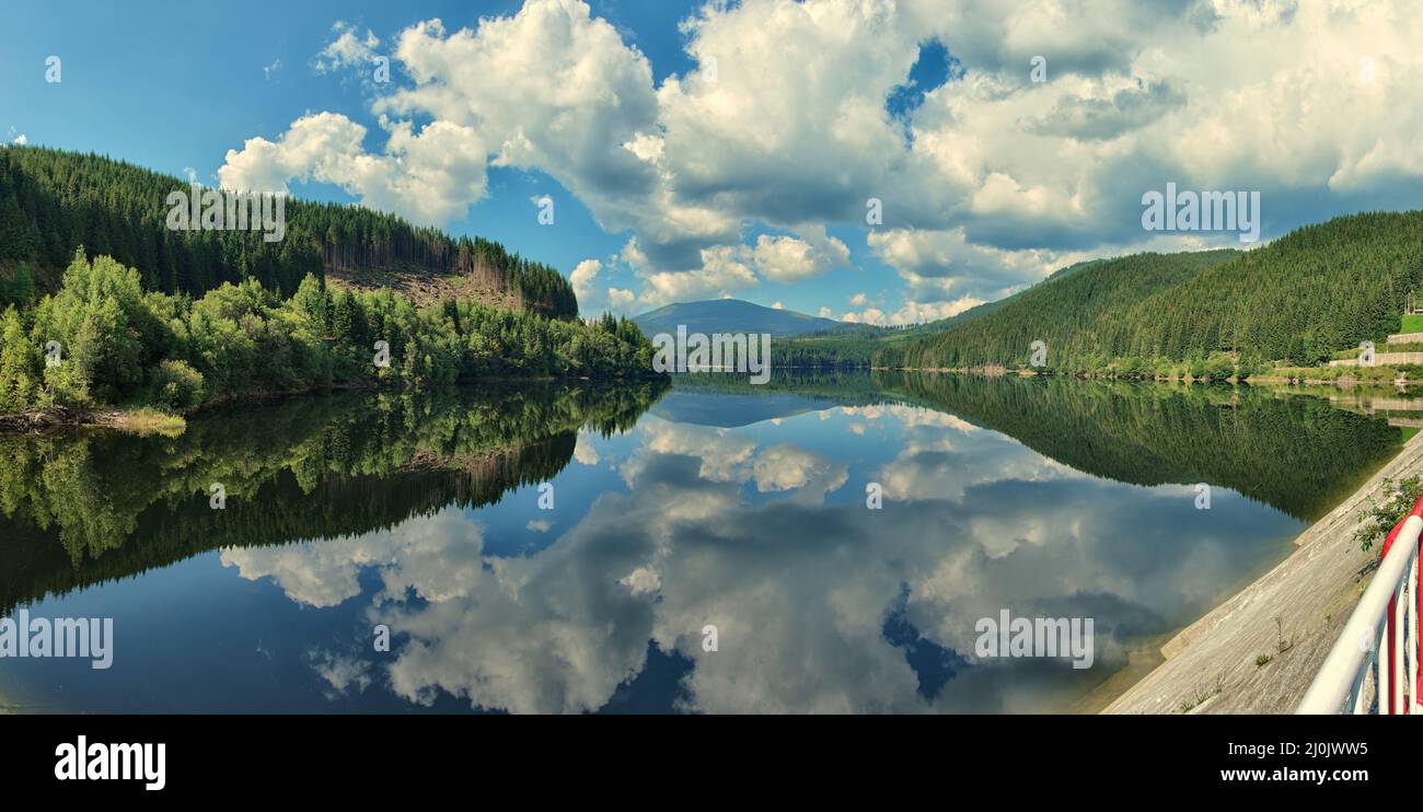 water reflection on lake of white clouds in blue sky of Romania Stock Photo