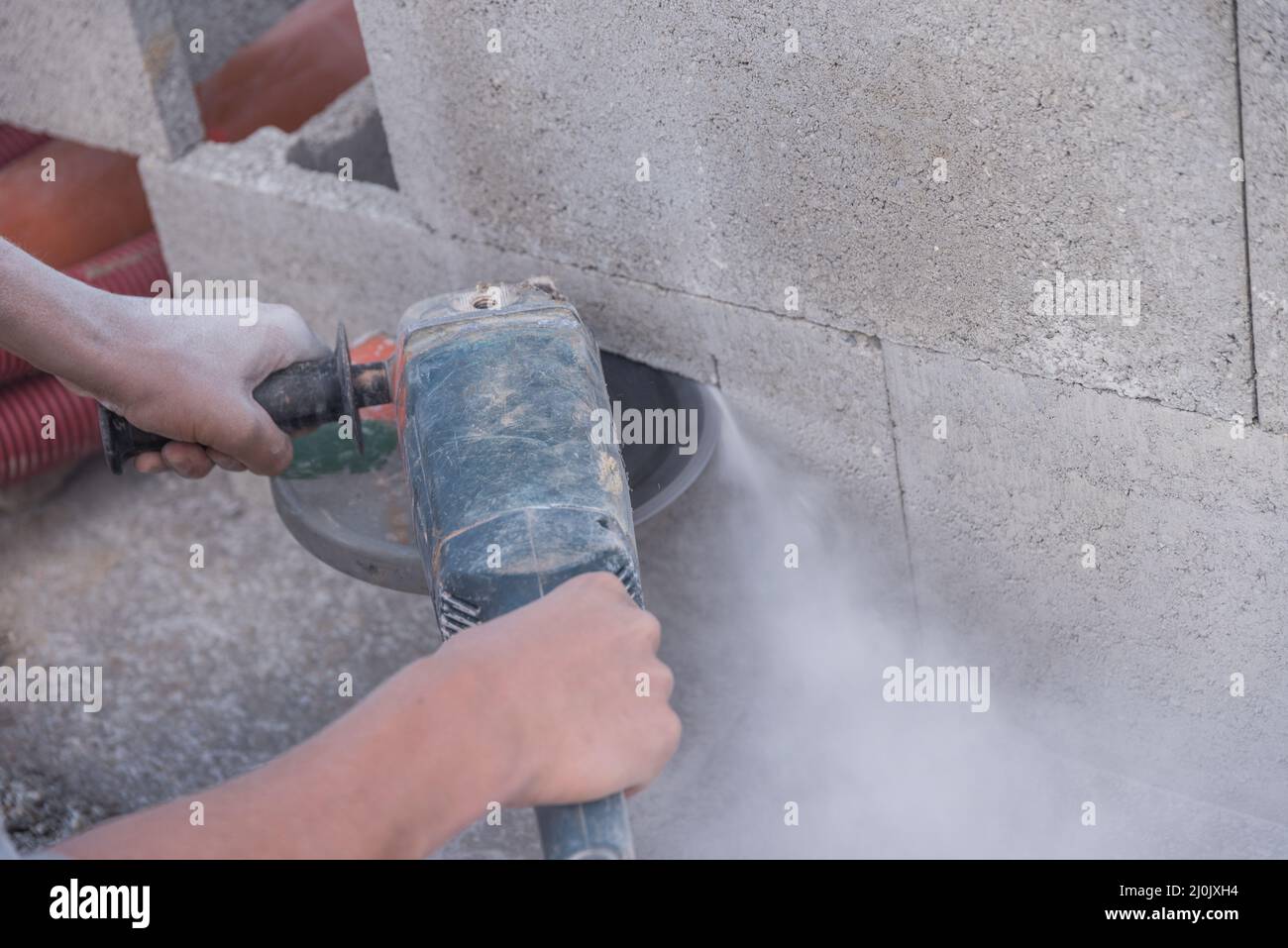Exposure of a construction worker with an angle grinder to dust and noise Stock Photo