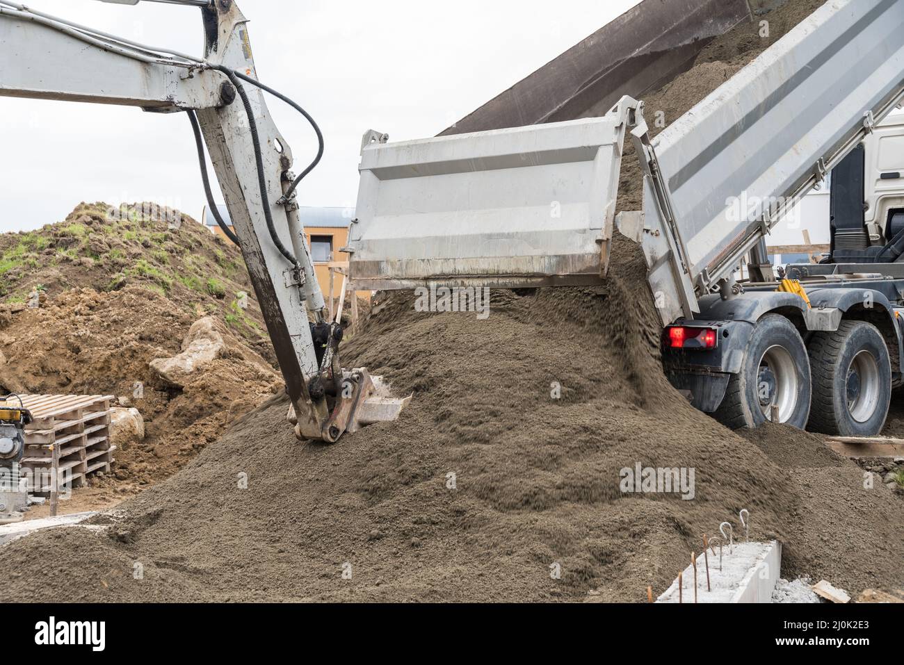 Excavator and truck unloading the delivery - construction site and ...