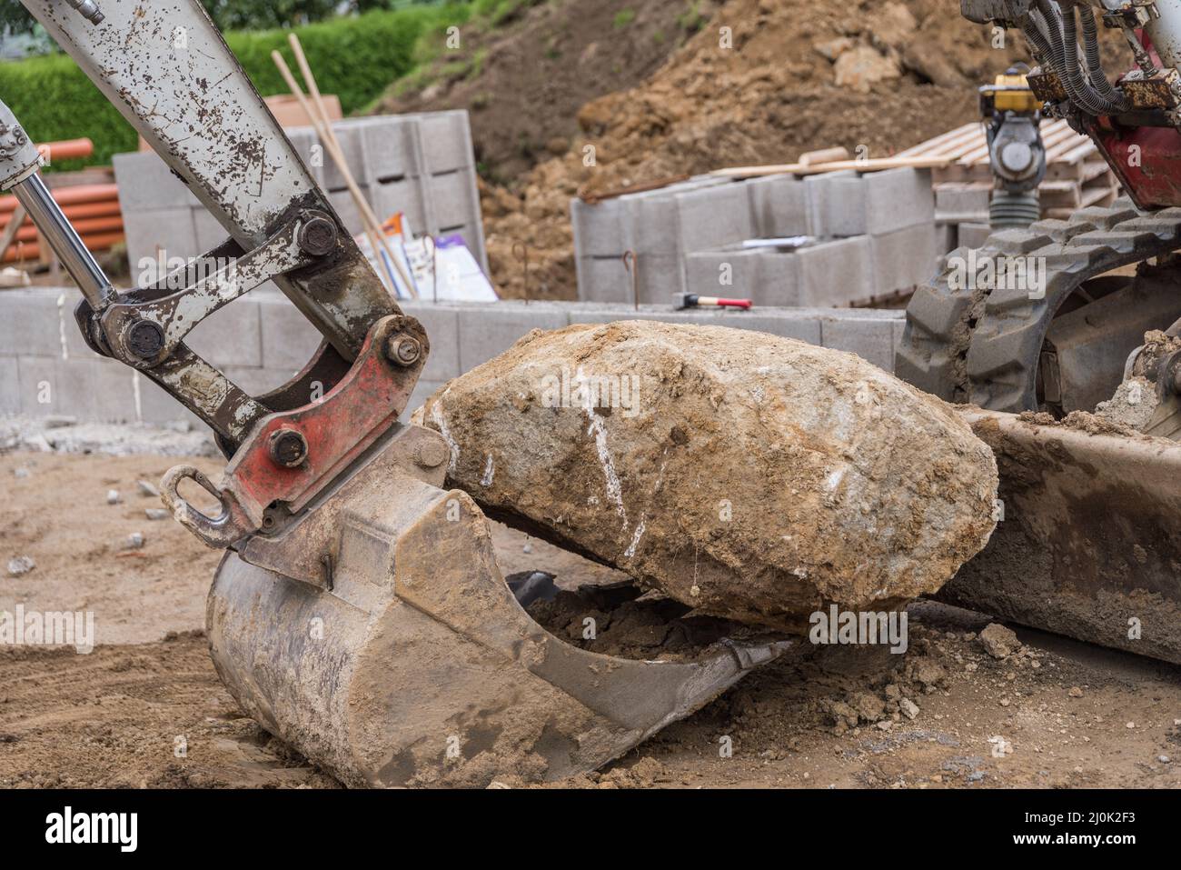 Excavator shovels large stone on excavator bucket - construction industry Stock Photo