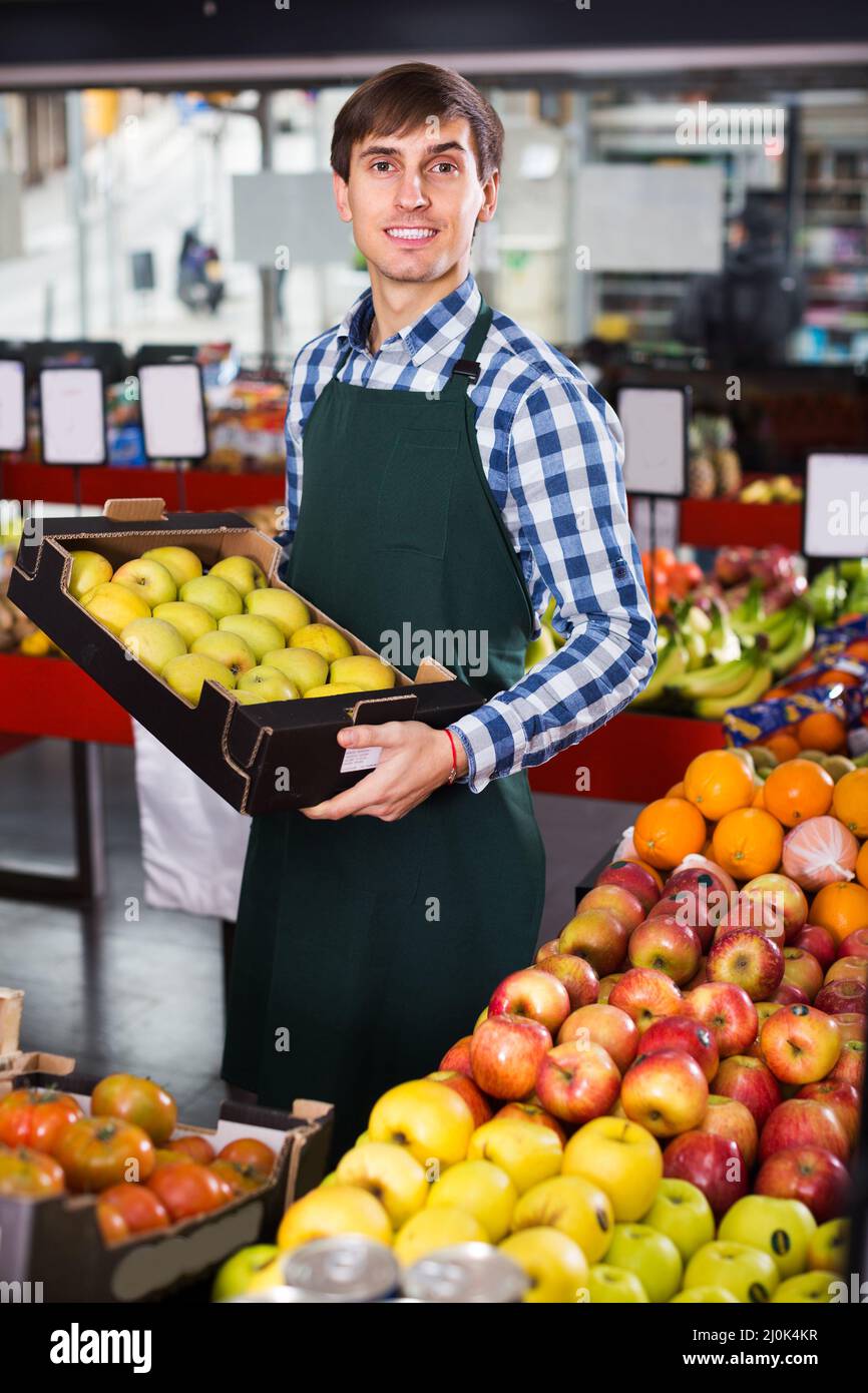 Grocery worker selling seasonal fruits Stock Photo - Alamy