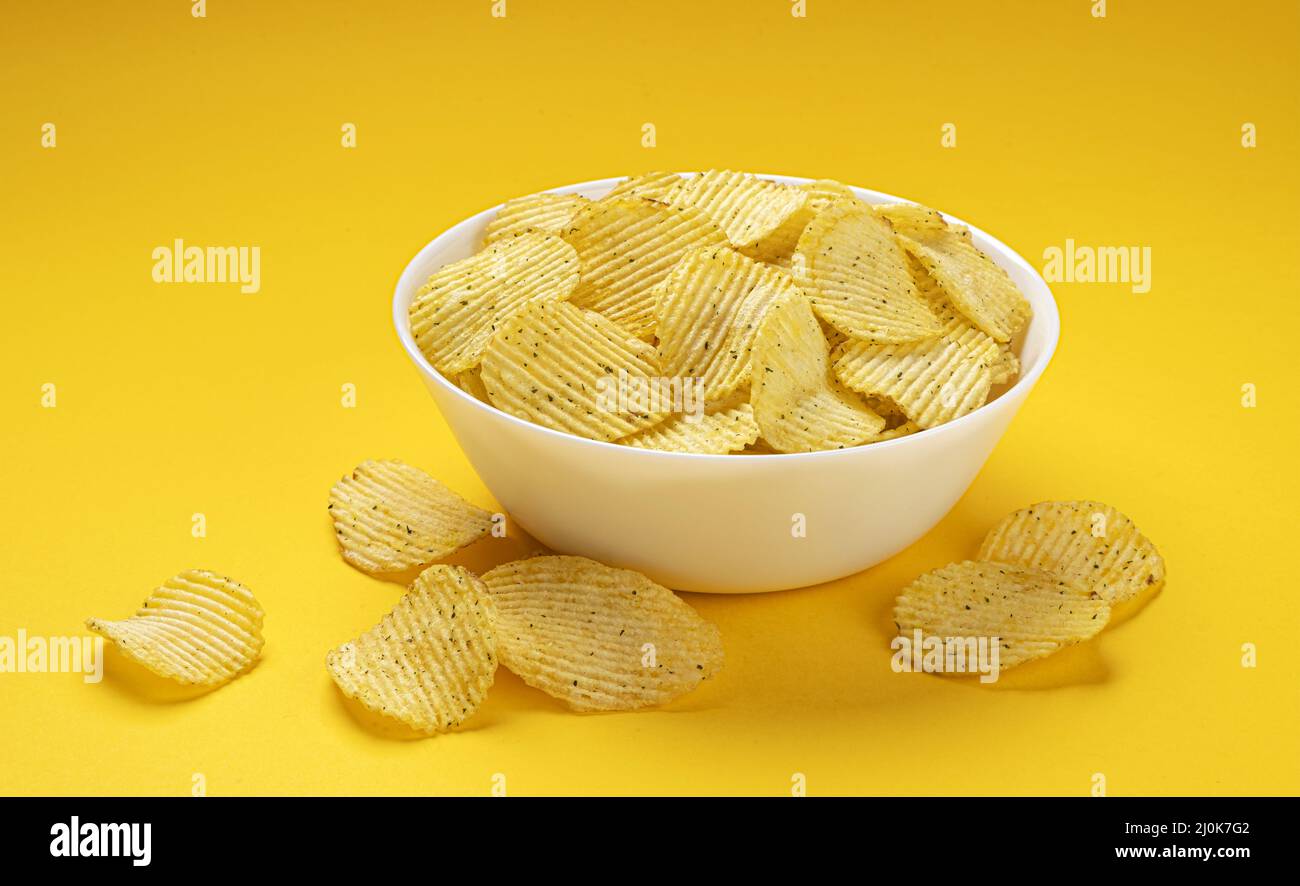Chip Pot Ridg Ridged potato chips in bowl on yellow background Stock Photo - Alamy
