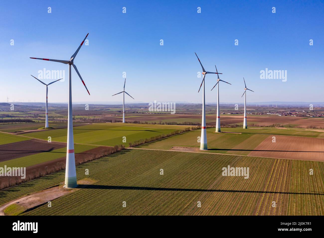 Wind turbines of a wind farm generate electricity for the Energiewende as an aerial view, Germany Stock Photo
