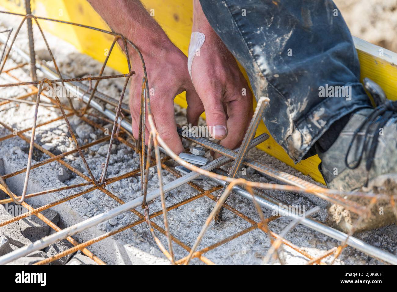 Construction worker working on construction site with ground wire and clamps - close-up Stock Photo