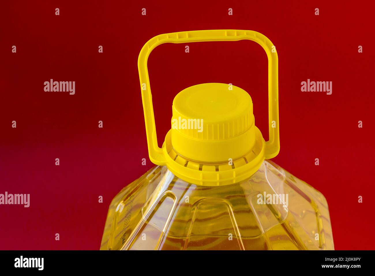 Five liter sunflower oil in a plastic bottle on red background,close-up taken Stock Photo