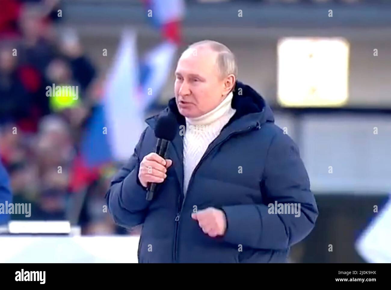 VLADIMIR PUTIN addresses a rally in Moscow on18 March 20223 to celebrate  the eighth anniversary of the annexation of Crimea. on Friday 18 March. He is wearing a white turtleneck sweater  from Italian company Kiton and a puffa jacket  by Loro Piana.Photo: Kremlin.ru Stock Photo