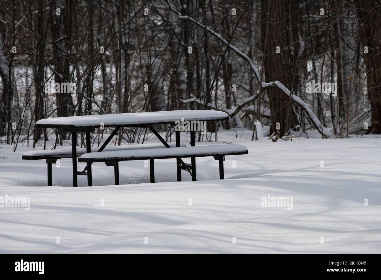 A picnic table in a park coverd in snow. Stock Photo