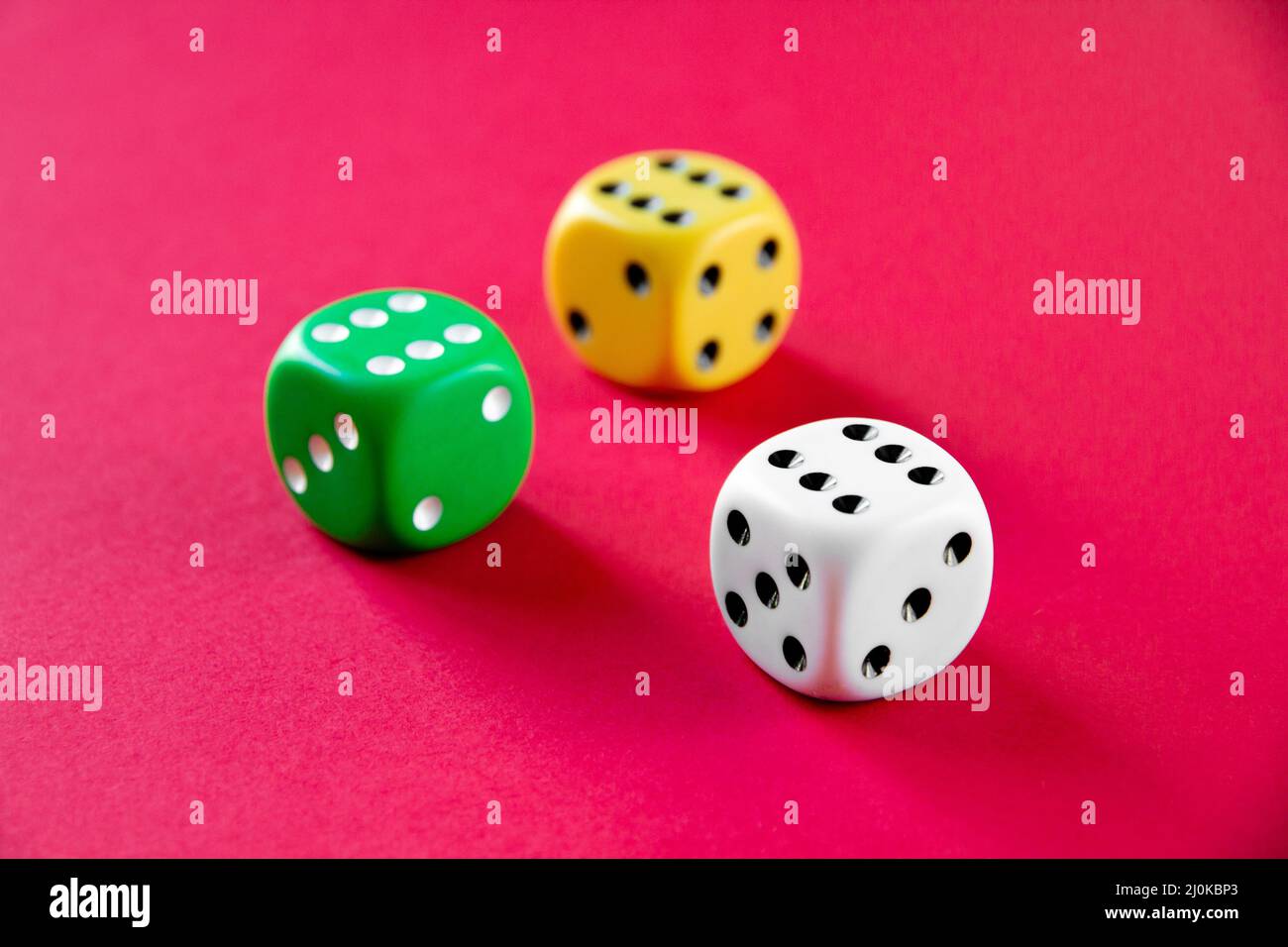 Three colorful dices isolated on pink background Stock Photo