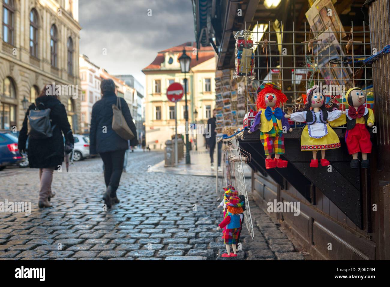 Tourists passing a dolls in a shop in old city of Prague Stock Photo