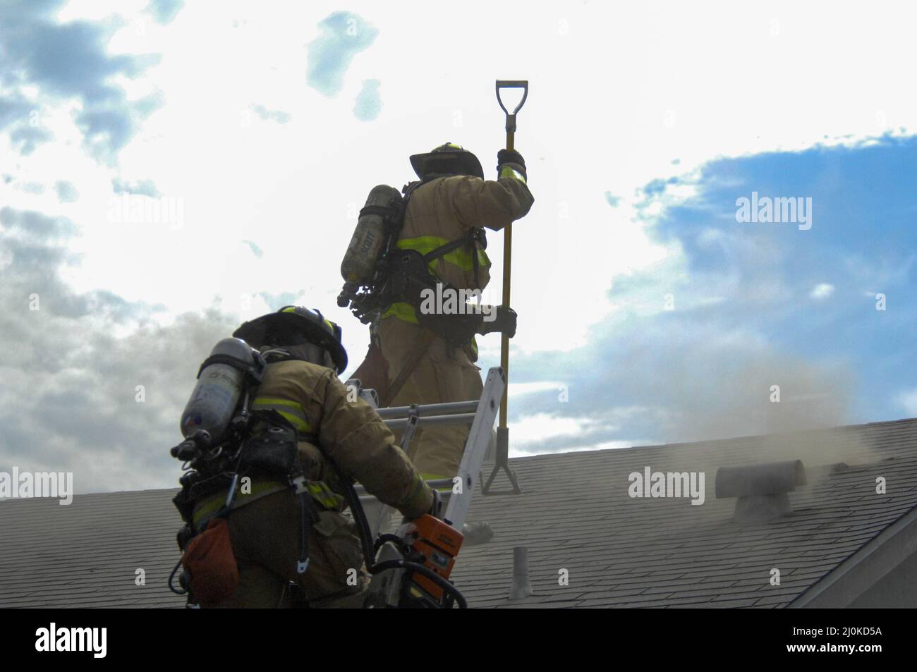San Diego City Firefighters working a structure fire performing ventilation Stock Photo