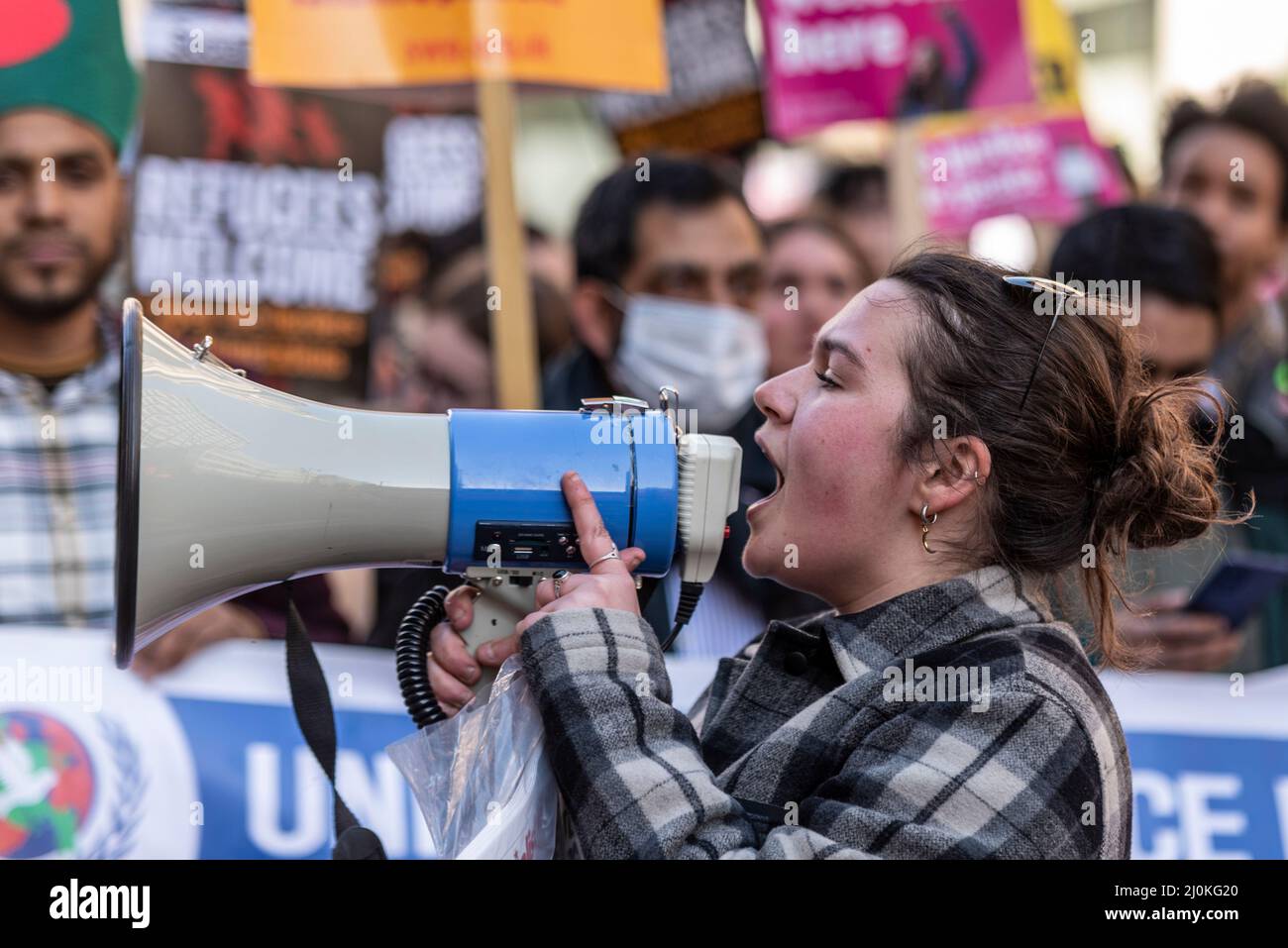 Protest taking place in London on UN Anti Racism Day. White, Caucasian female shouting through a megaphone Stock Photo