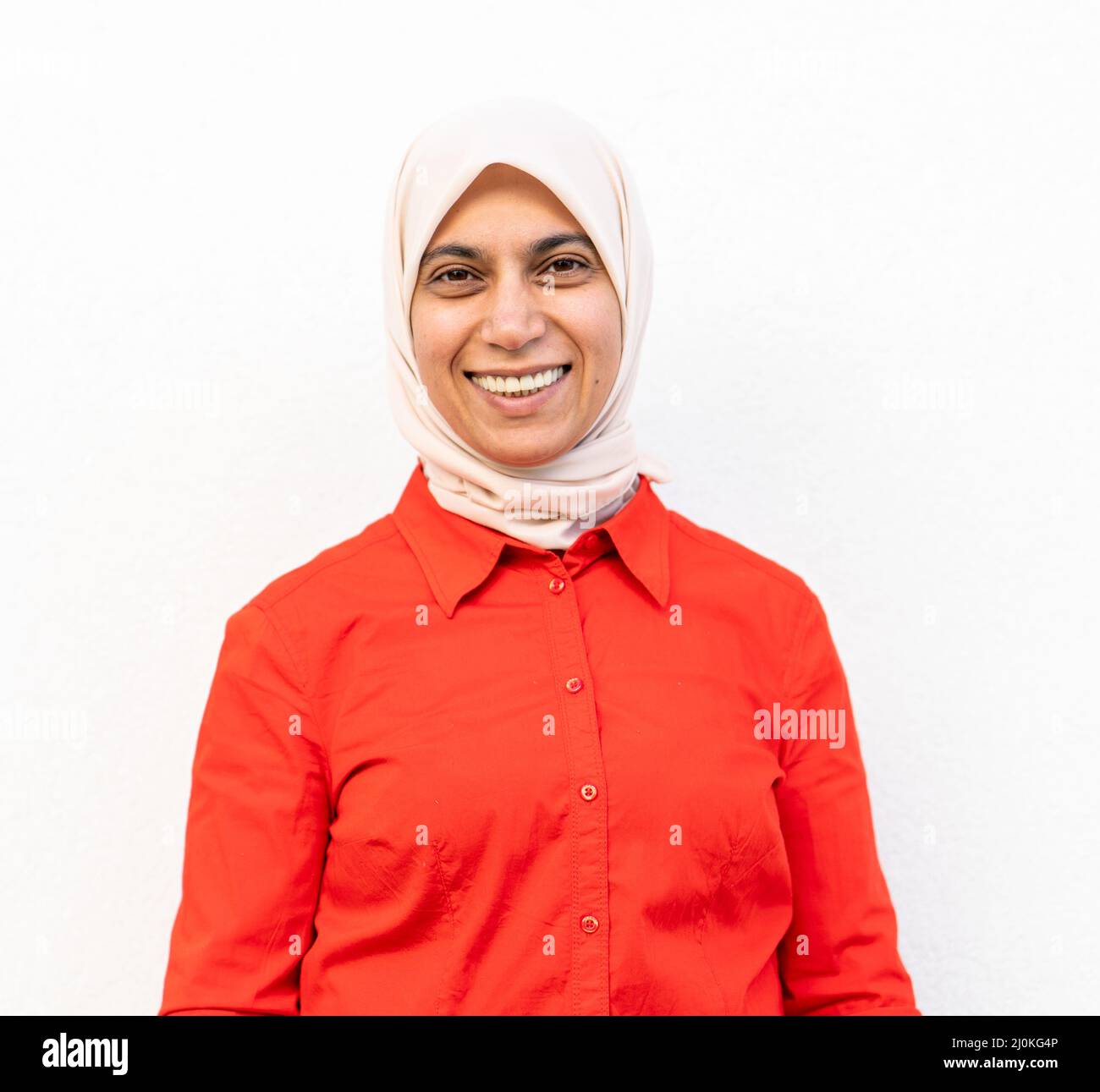 Smiling Muslim woman portrait against the wall Stock Photo